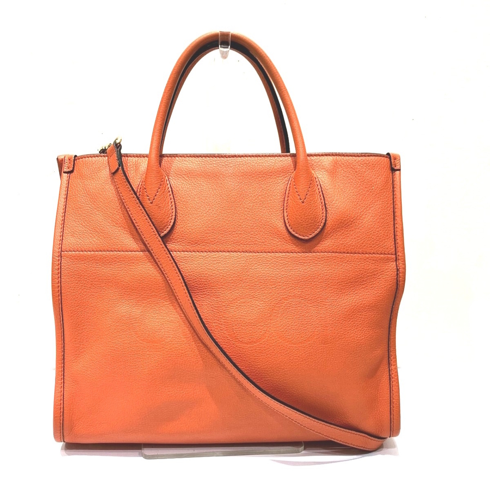 Gucci orange leather tote bag prominent embossed logo